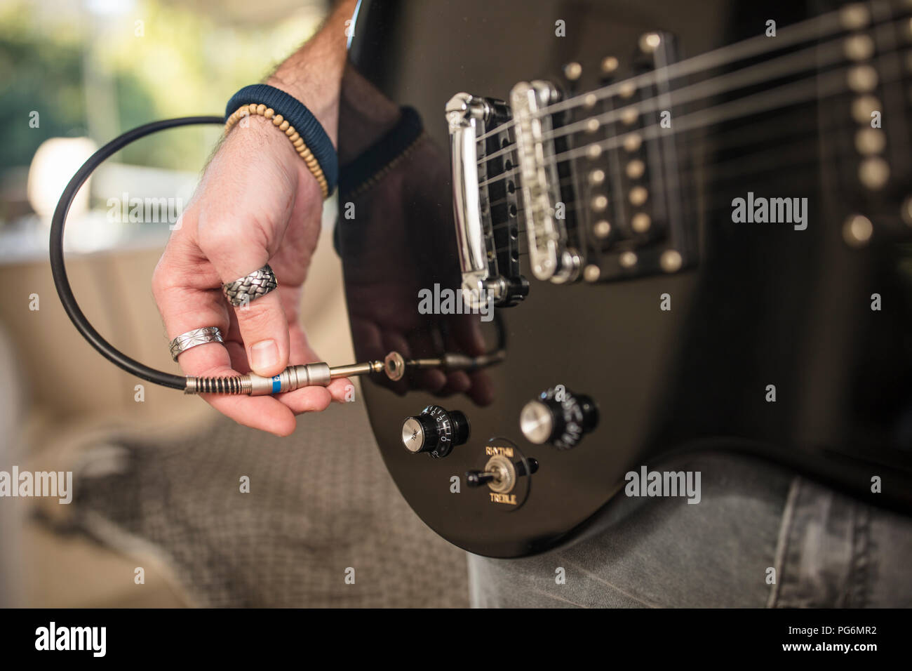 Close-up of man's hand plugging electric guitar Stock Photo