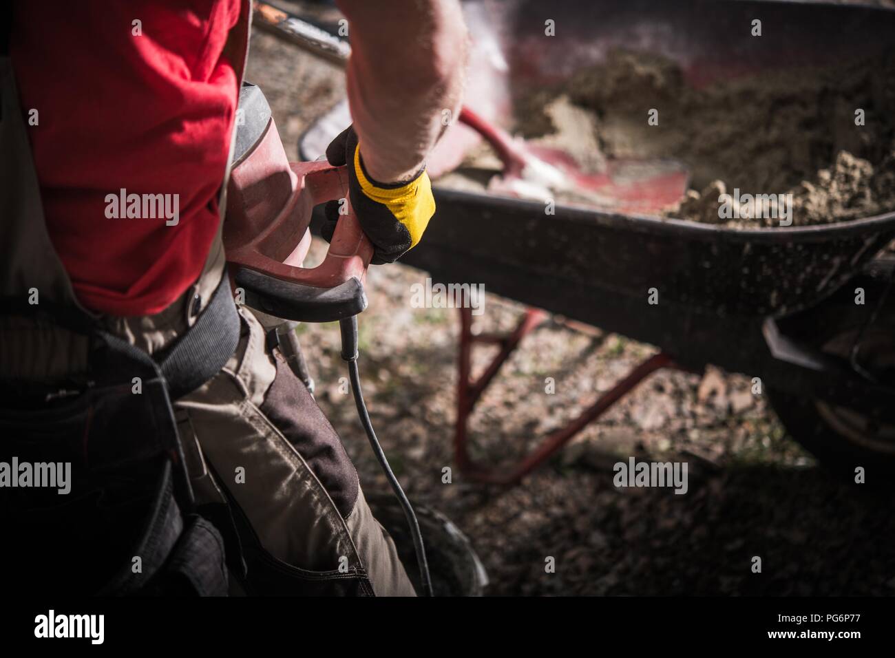 House Building Crew in Action. Caucasian Contractor Mixing Concrete with Power Tool. Stock Photo