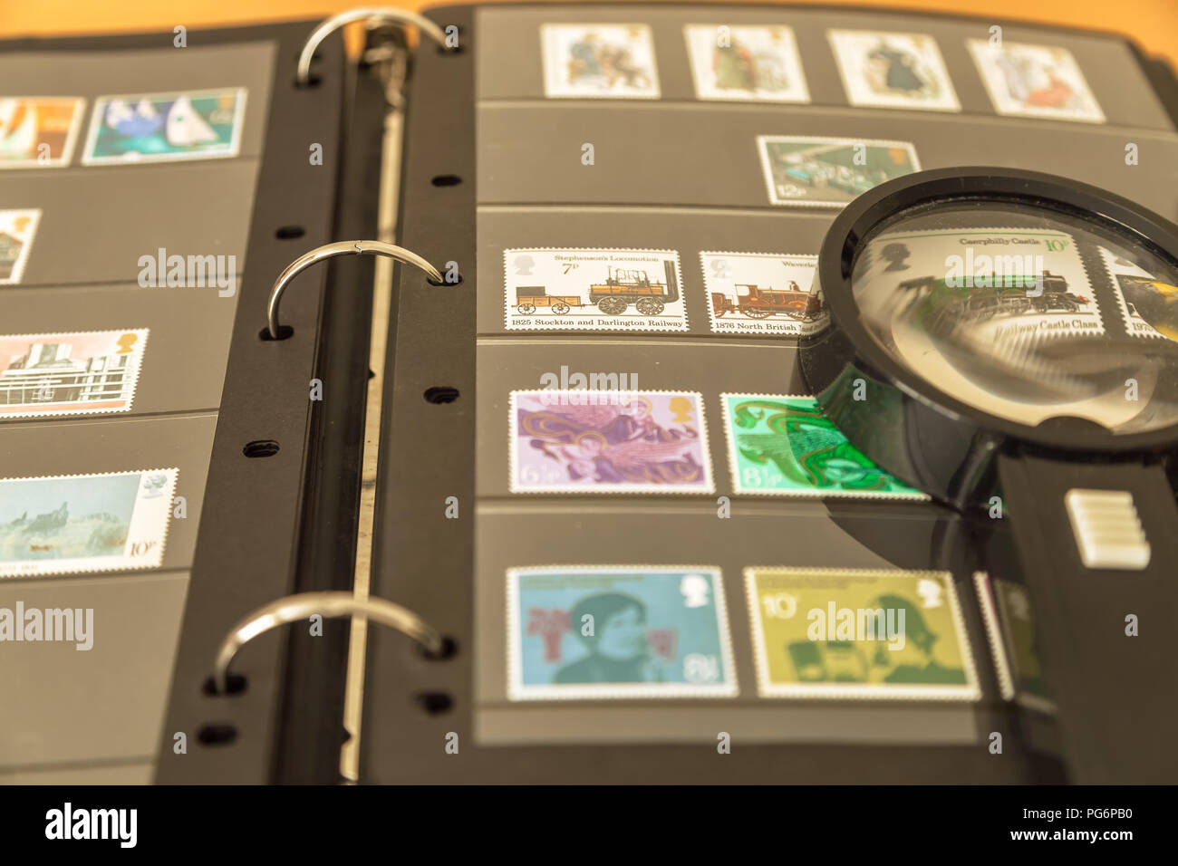 Royal Mail stamps album with magnifying glass Stock Photo Alamy