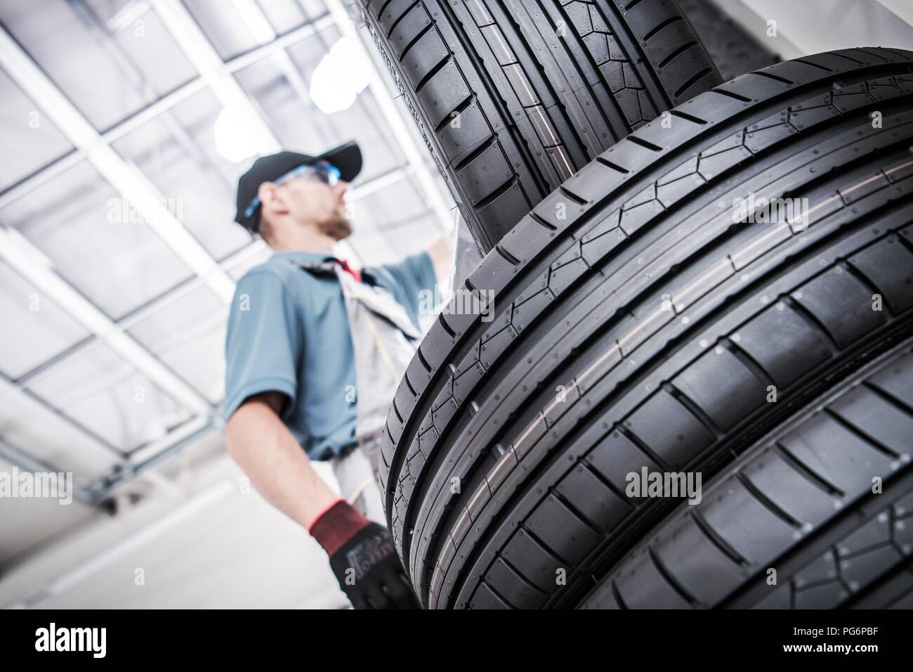 Replacing Old Car Tires. Vulcanization Service Worker and New Tires. Stock Photo