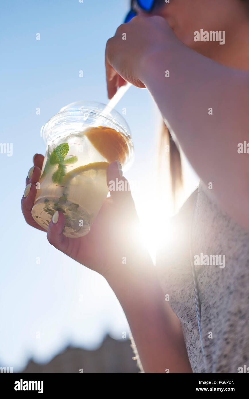 Woman drinking lemonade from plastic cup, close-up Stock Photo