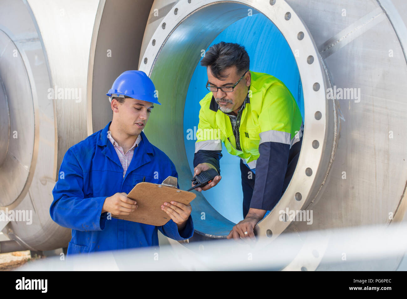 Worker in a tank talking to co-worker Stock Photo