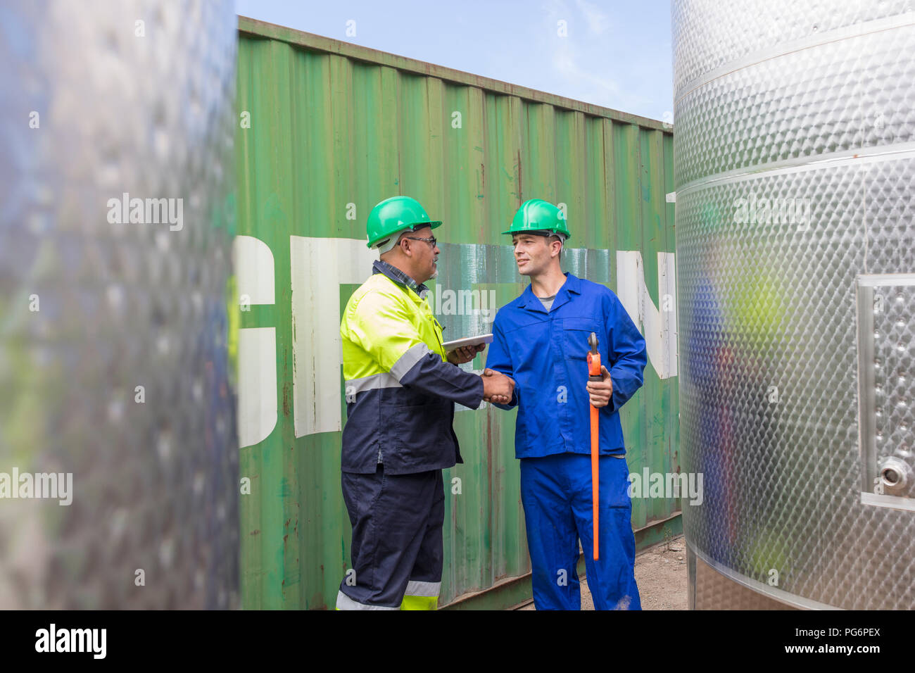 Two workers at container shaking hands Stock Photo