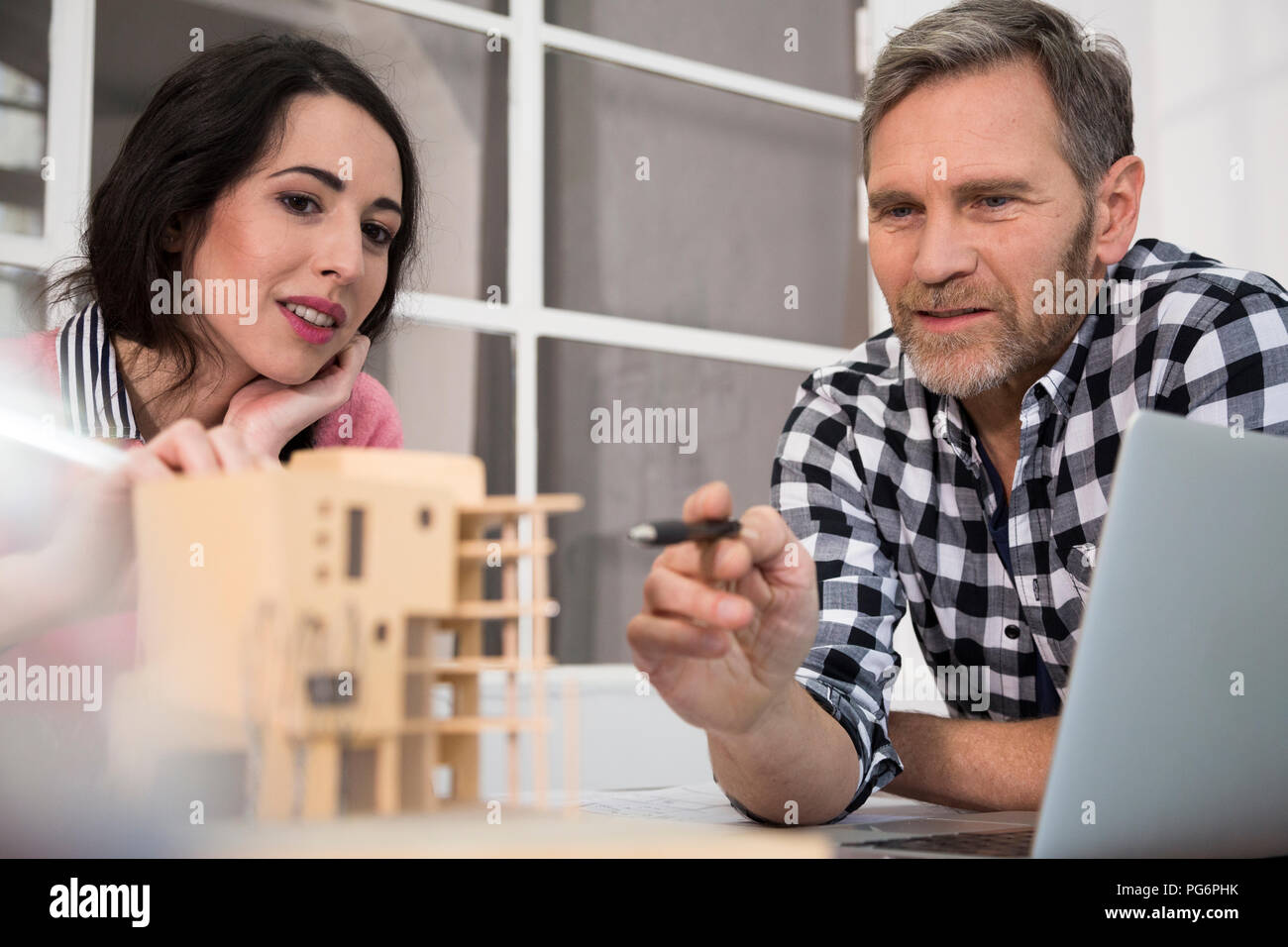 Colleagues discussing architectural model in office Stock Photo