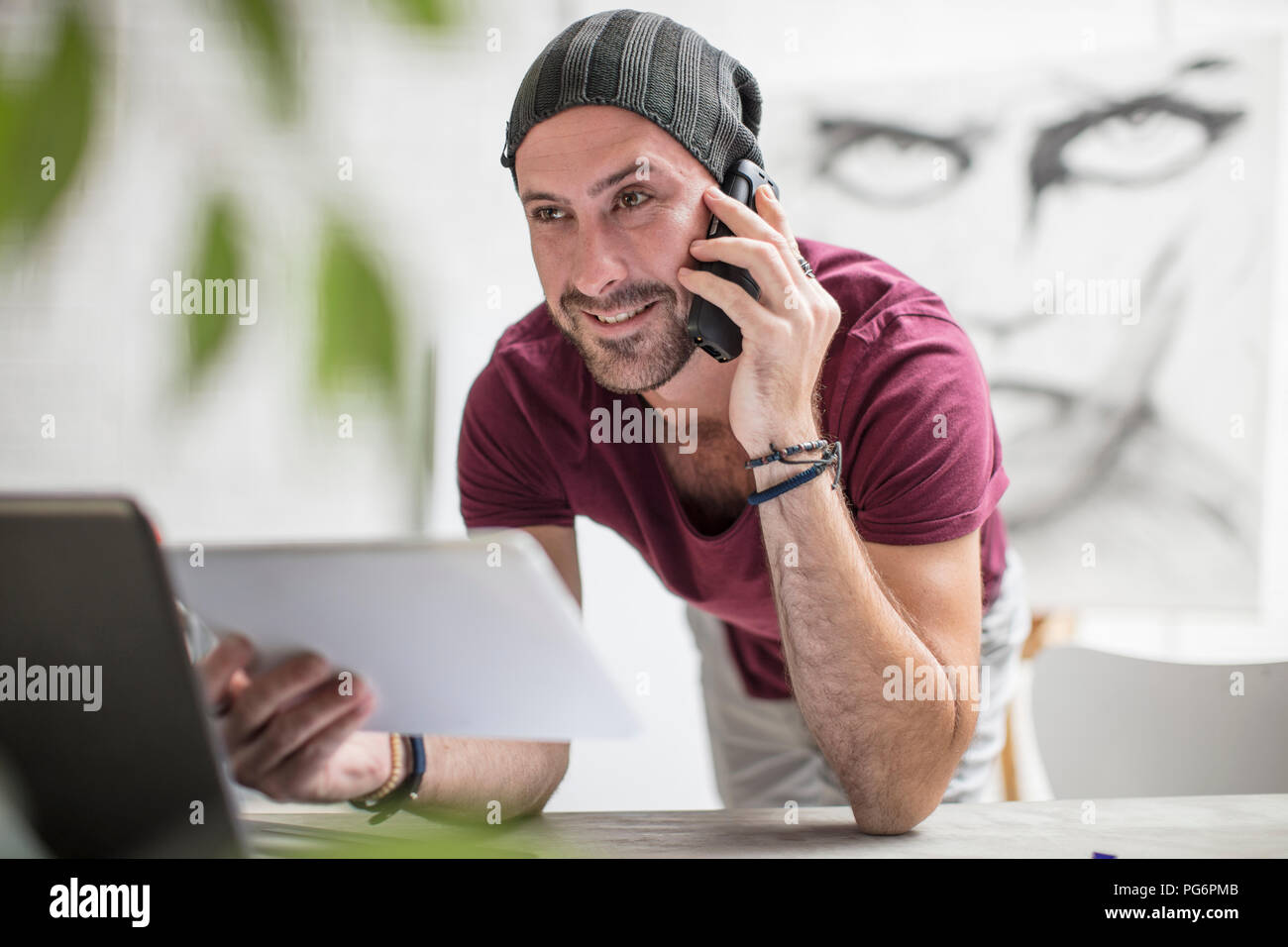 Artist using tablet and cell phone in studio Stock Photo