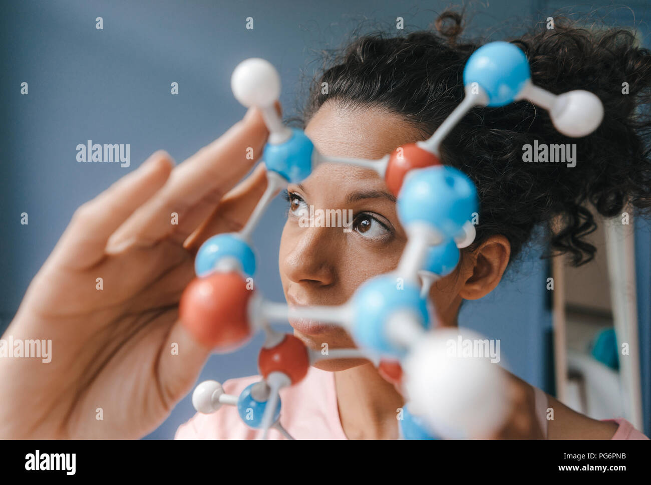 Female scientist holding molecule model, looking for solutions Stock Photo