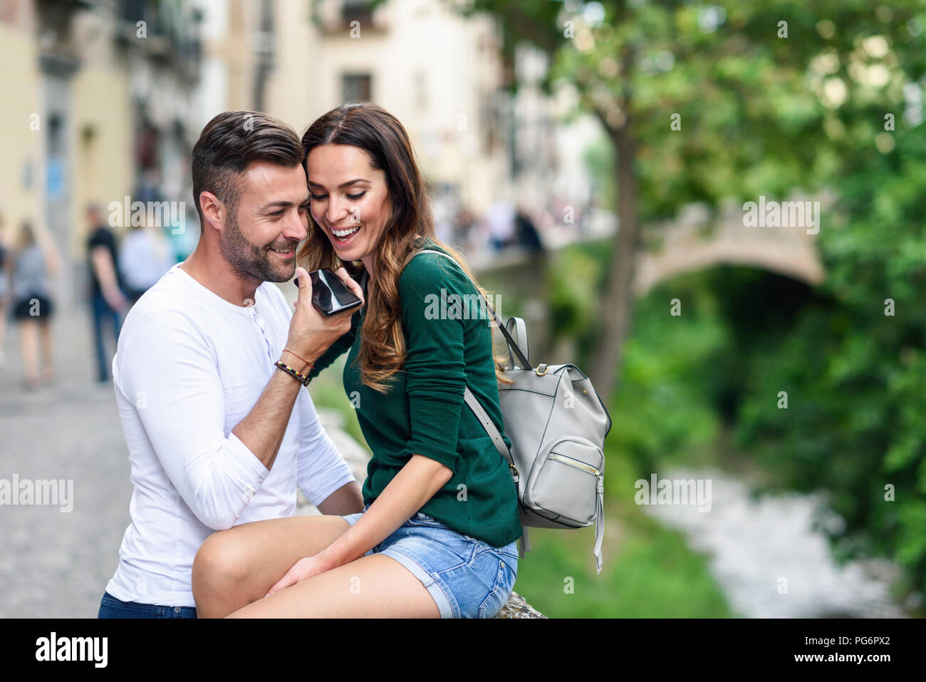 Happy tourist couple using cell phone in the city Stock Photo