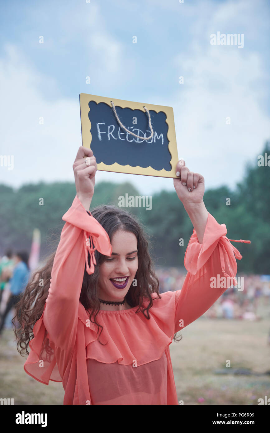 Woman holding sign at music festival, freedom Stock Photo