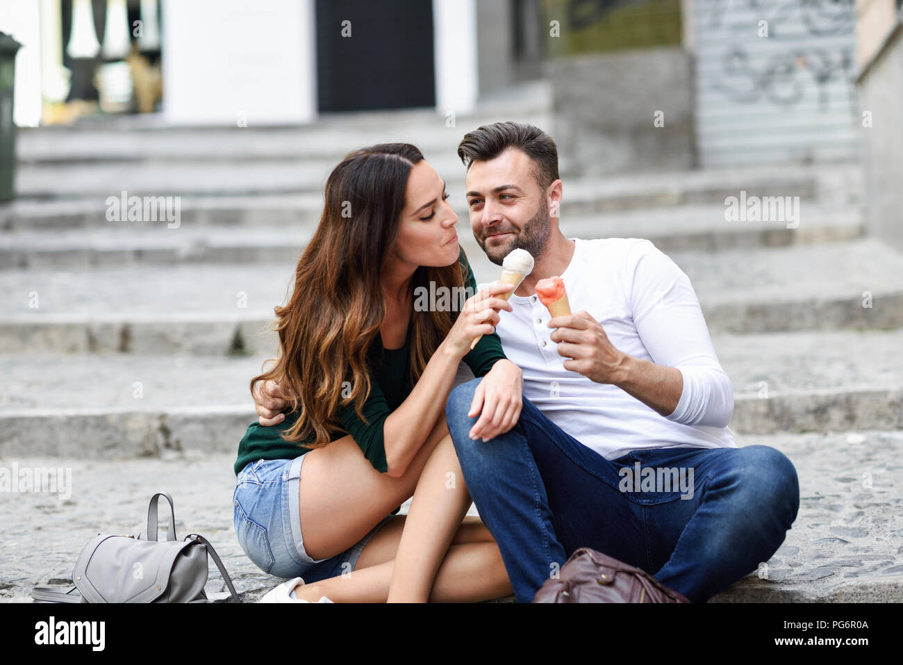 Tourist couple sharing ice cream cones in the city Stock Photo
