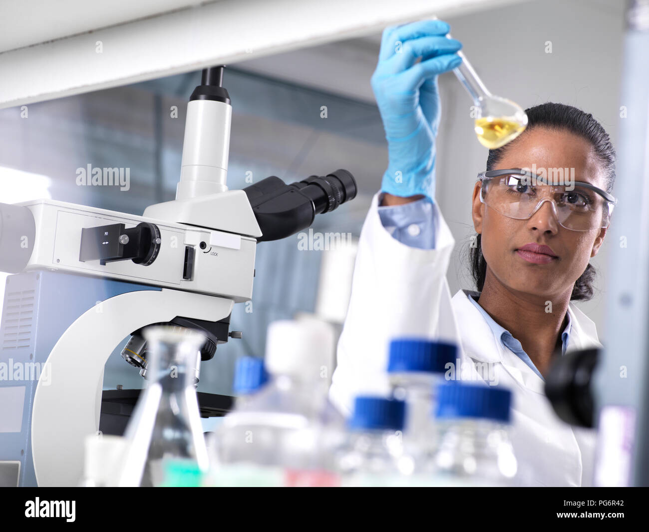 Biotechnology Research, female scientist mixing a chemical formula Stock Photo