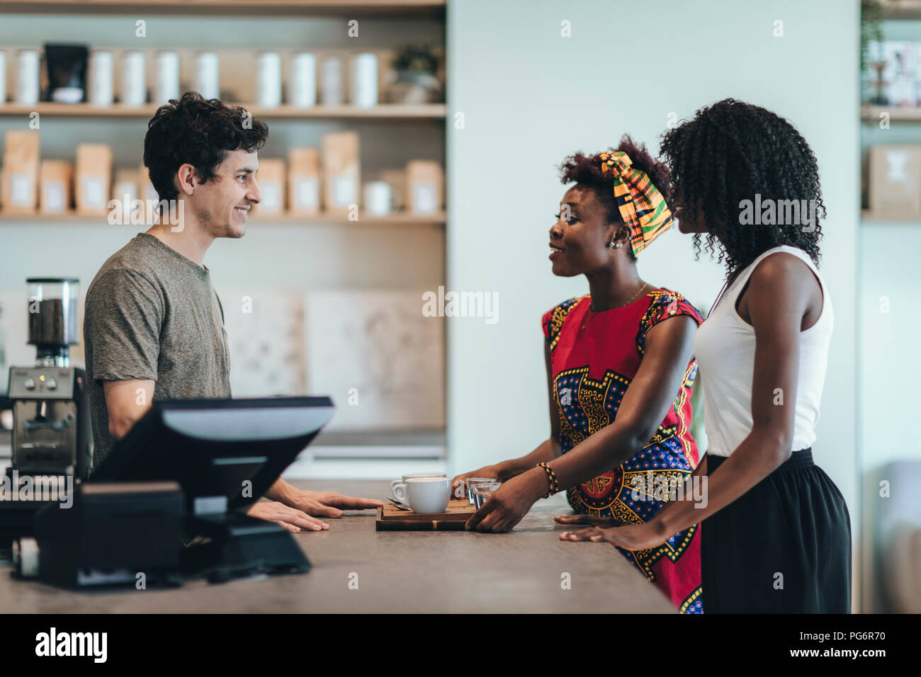 Waiter talking to customers in a coffee bar Stock Photo