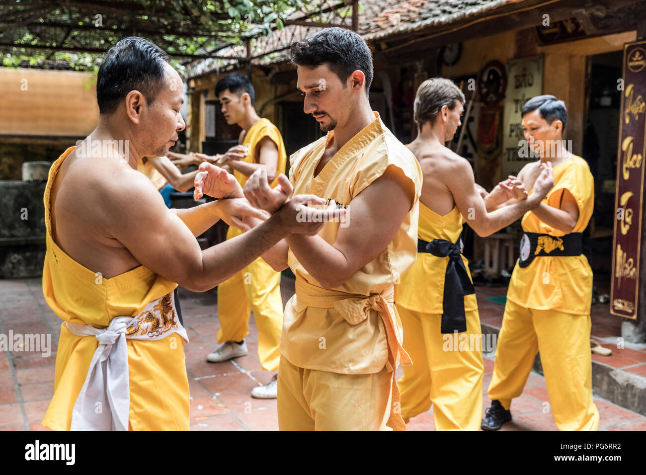 Vietnam, Hanoi, men exercising kung fu, european man learning kung fu