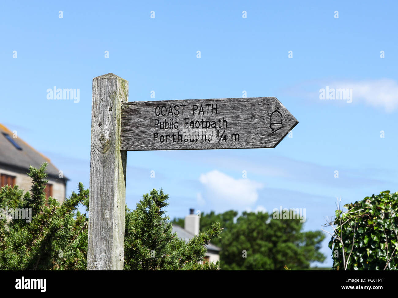 A wooden footpath finger post saying Coast Path , public footpath to Porthcurno 1/4 miles, Cornwall, England Stock Photo