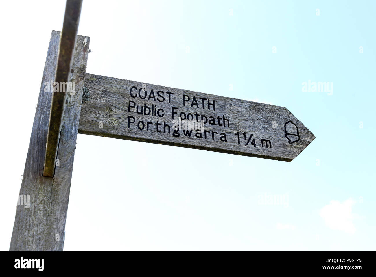 A wooden footpath finger post saying Coast Path , public footpath to Porthgwarra 1 1/4 miles, Cornwall, England Stock Photo