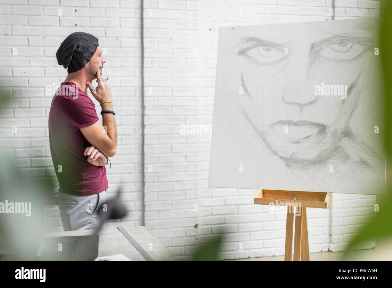 Artist looking at drawing in studio Stock Photo