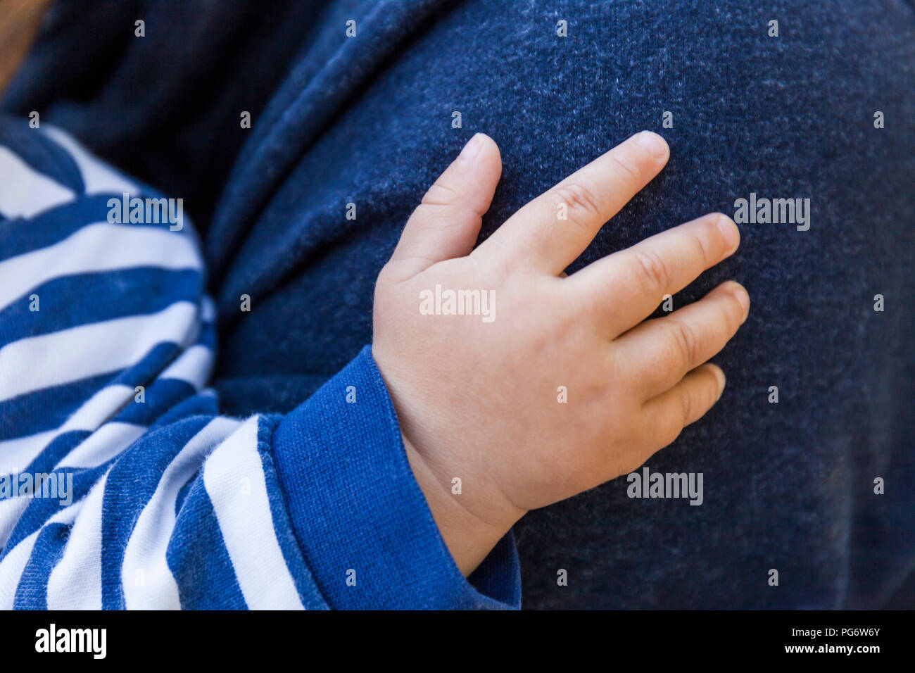 Hand of baby boy on father's shoulder, close-up Stock Photo