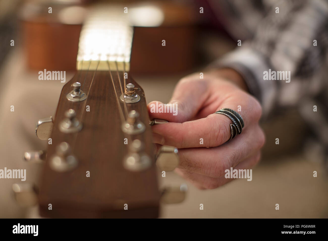 Close-up of man's hand tuning guitar Stock Photo