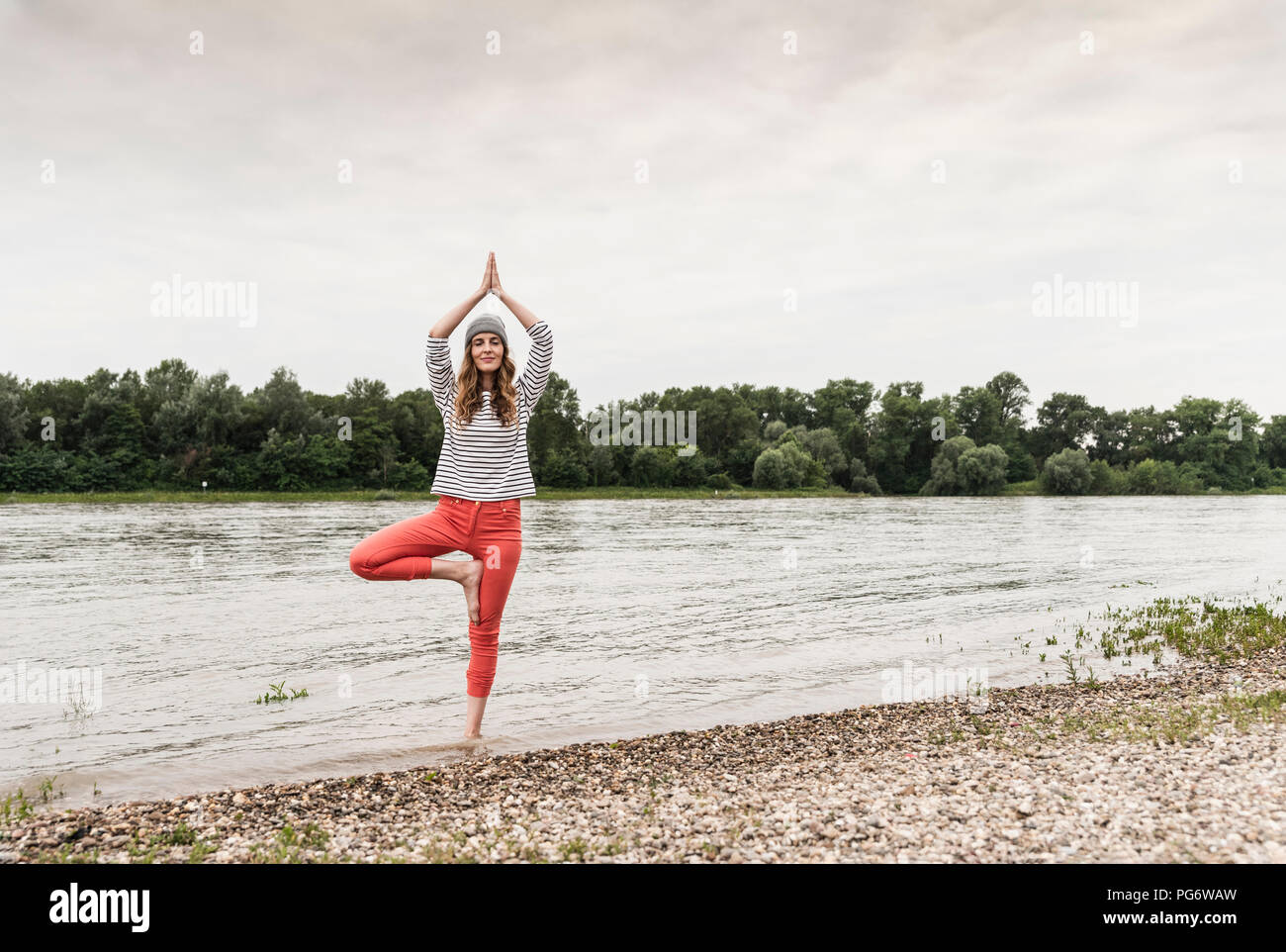 Woman practicing yoga in a river Stock Photo