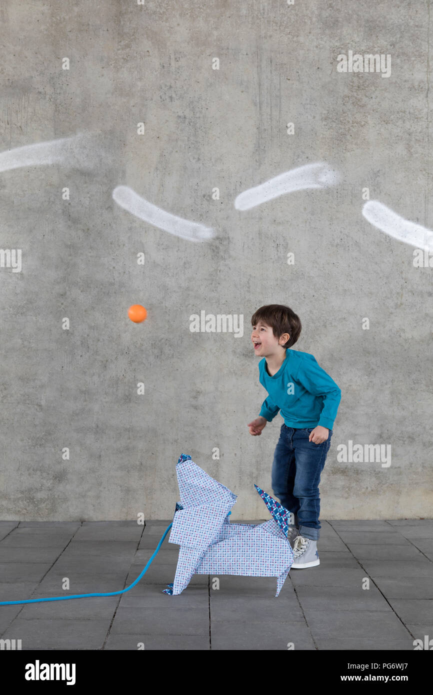 Little boy playing with ball, origami dog Stock Photo