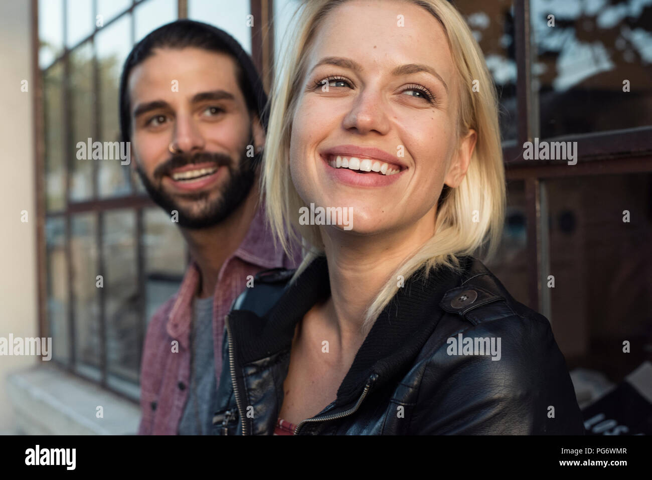Happy young couple outdoors looking sideways Stock Photo