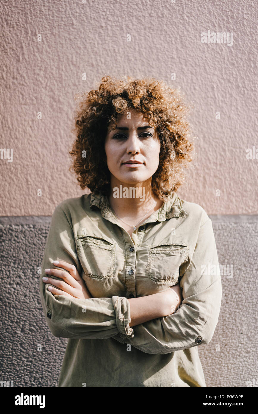 Woman with arms crossed, looking defiant, portrait Stock Photo