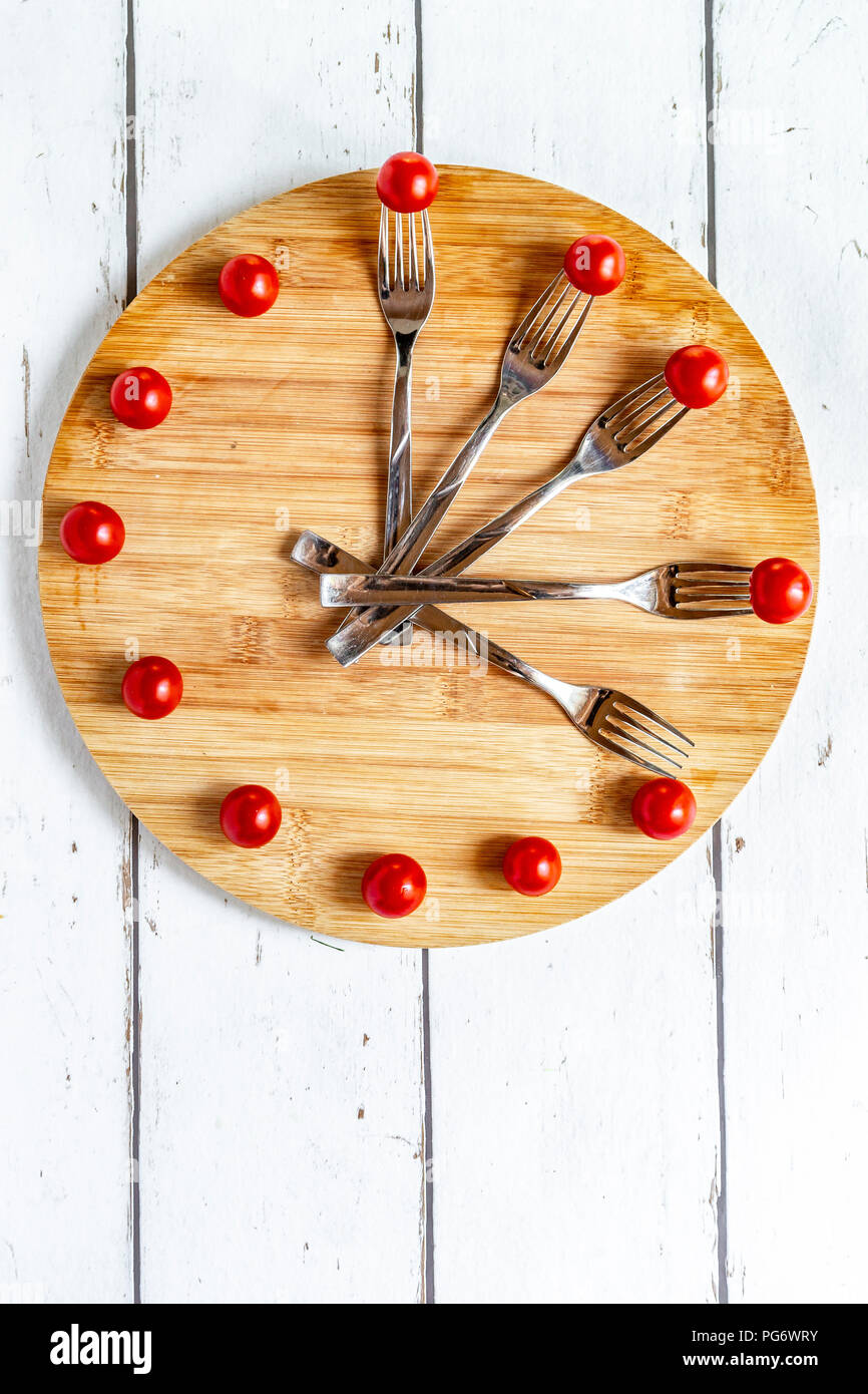 Vegetables on round chopping board, symbol for intermittent fasting Stock Photo