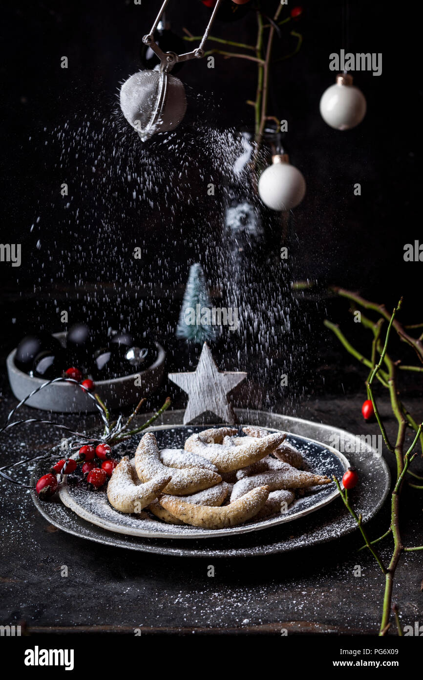 Sprinkling almond cookies with icing sugar Stock Photo