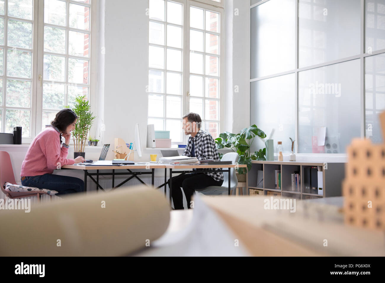 Colleagues working at desk in a loft office Stock Photo - Alamy