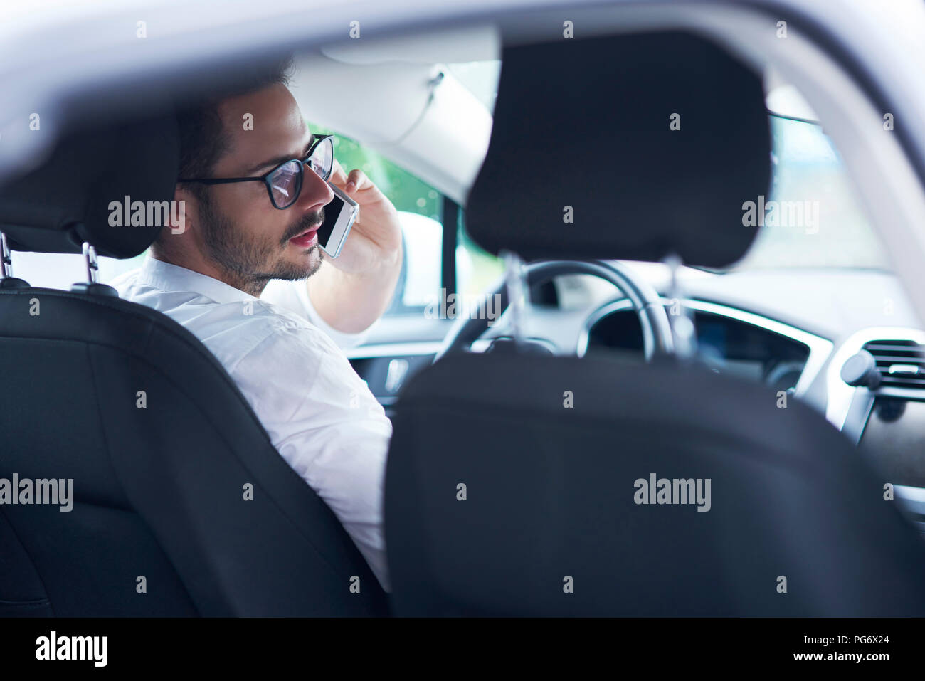 Businessman sitting in car talking on the phone Stock Photo