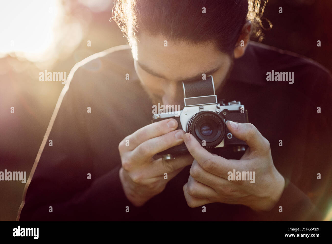 Young man photographing with analogue camera Stock Photo