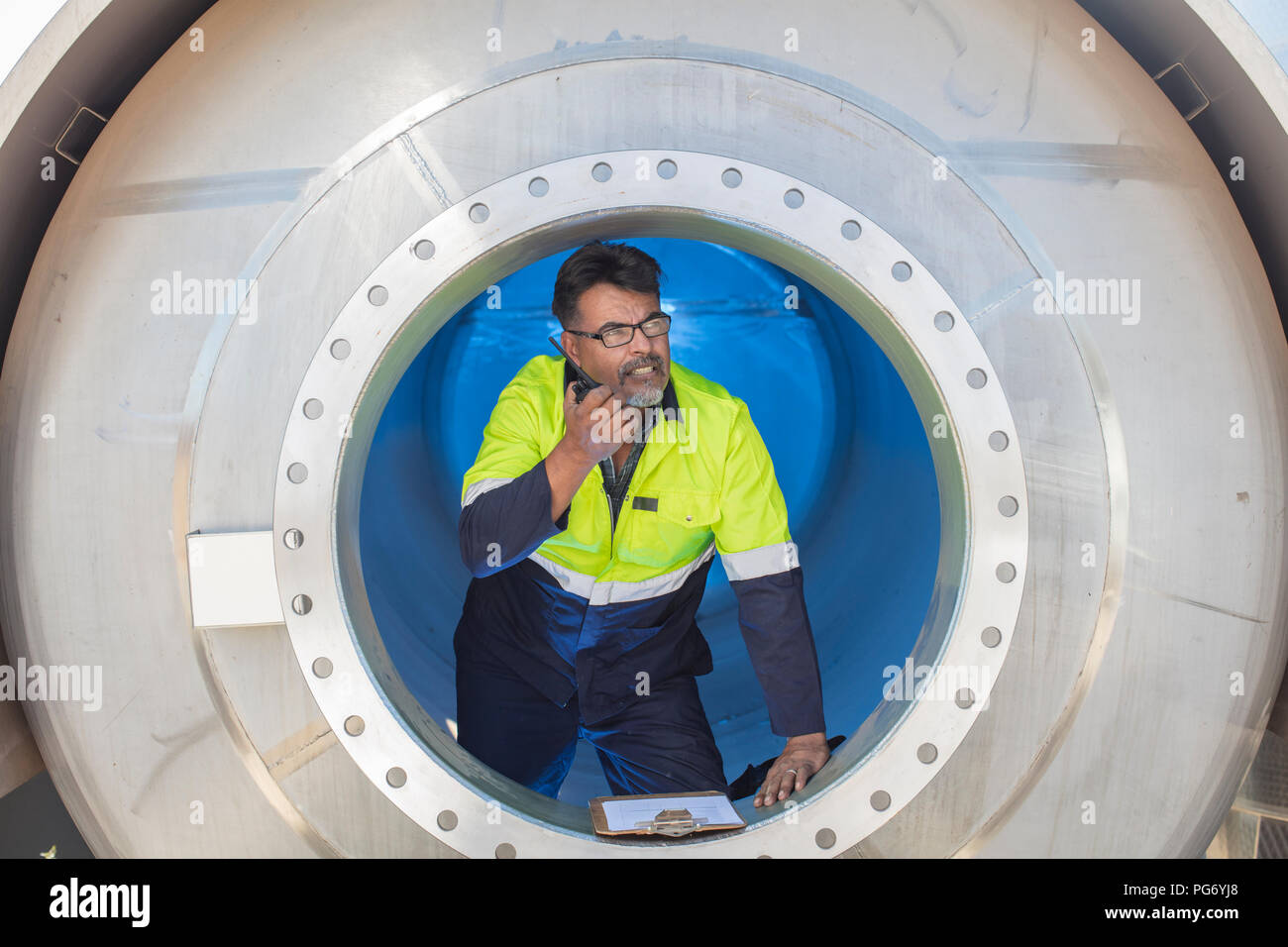 Worker in a tank using walkie talkie Stock Photo