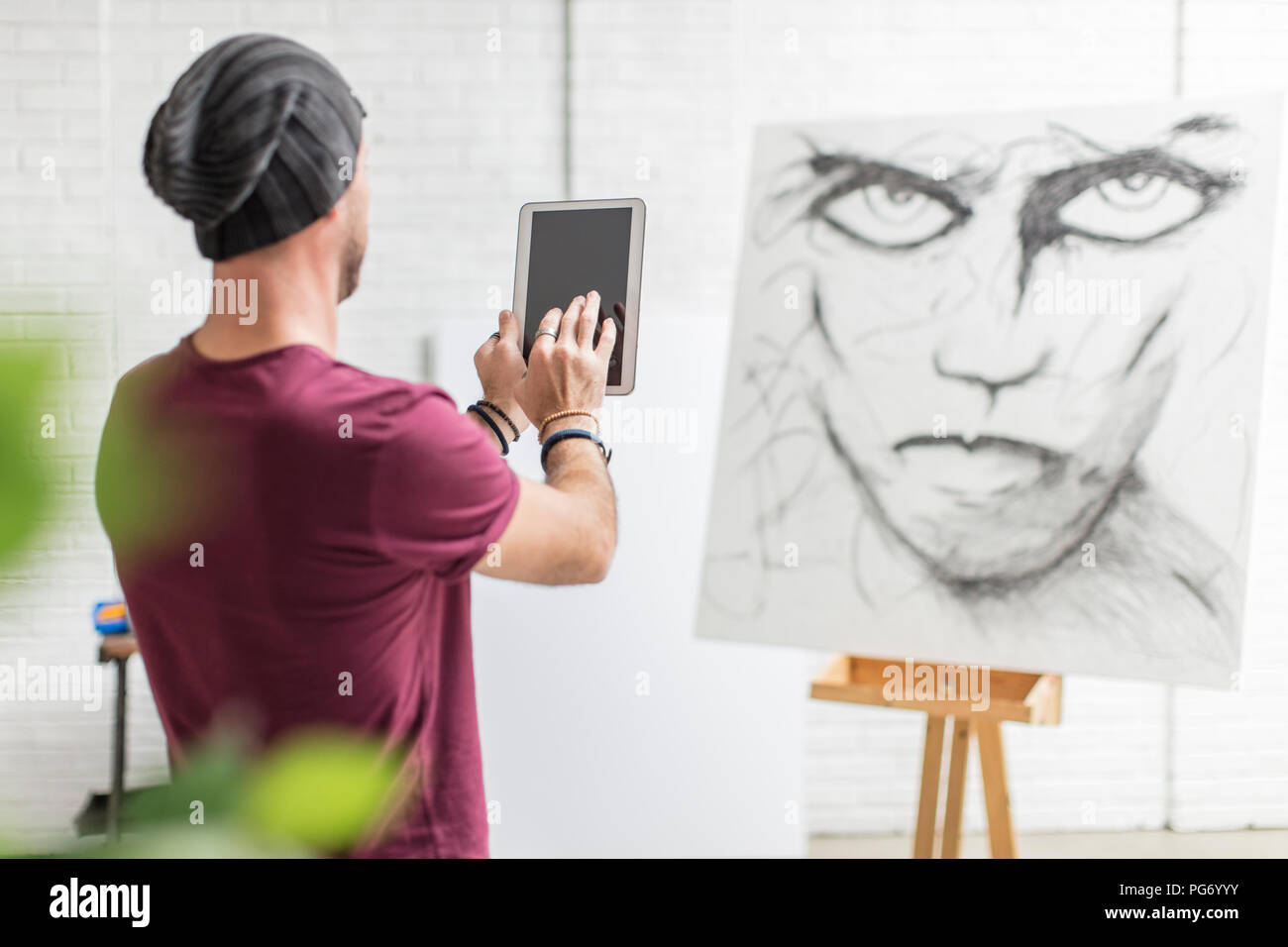 Artist taking photo of his drawing in studio Stock Photo