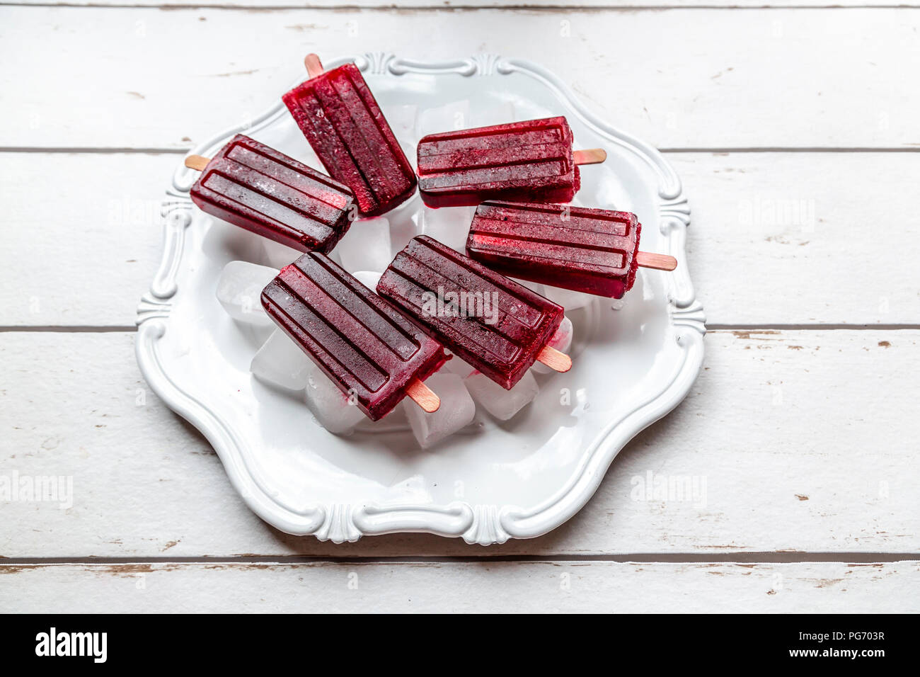 Cherry ice lollies on ice cubes and plate Stock Photo