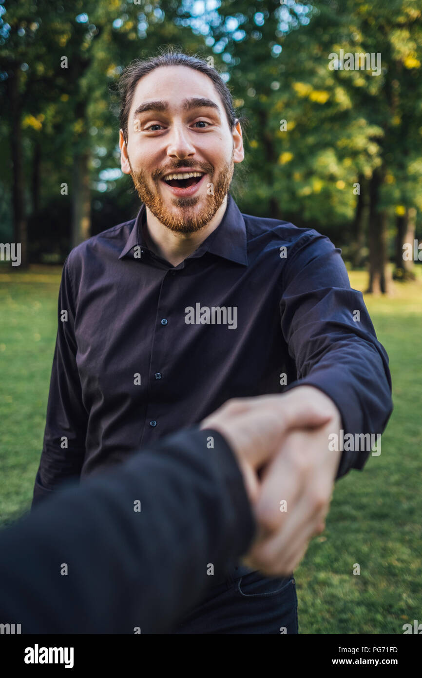 Young businessman greeting business partner in a park, negotiating business transactions Stock Photo