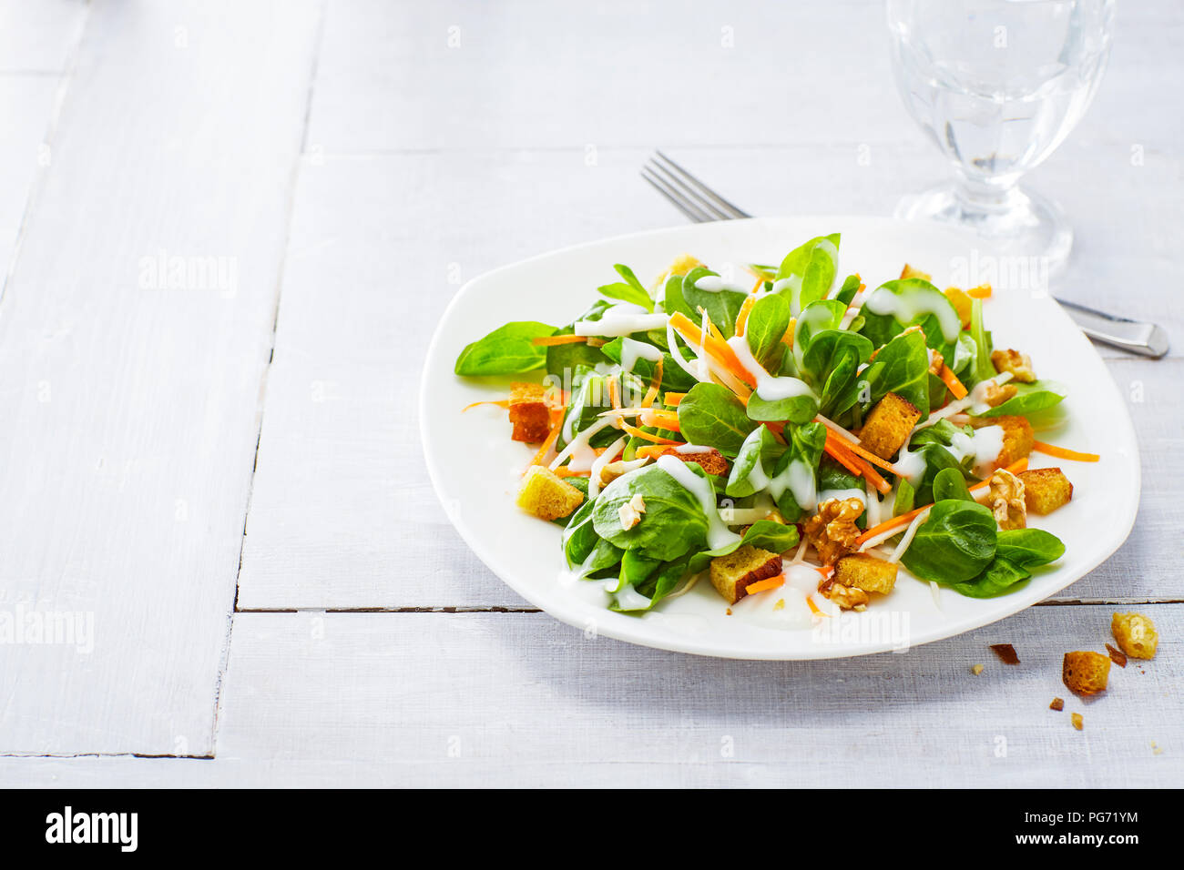 Autumnal salad with lamb's lettuce, carrots, slaw, croutons and walnuts Stock Photo