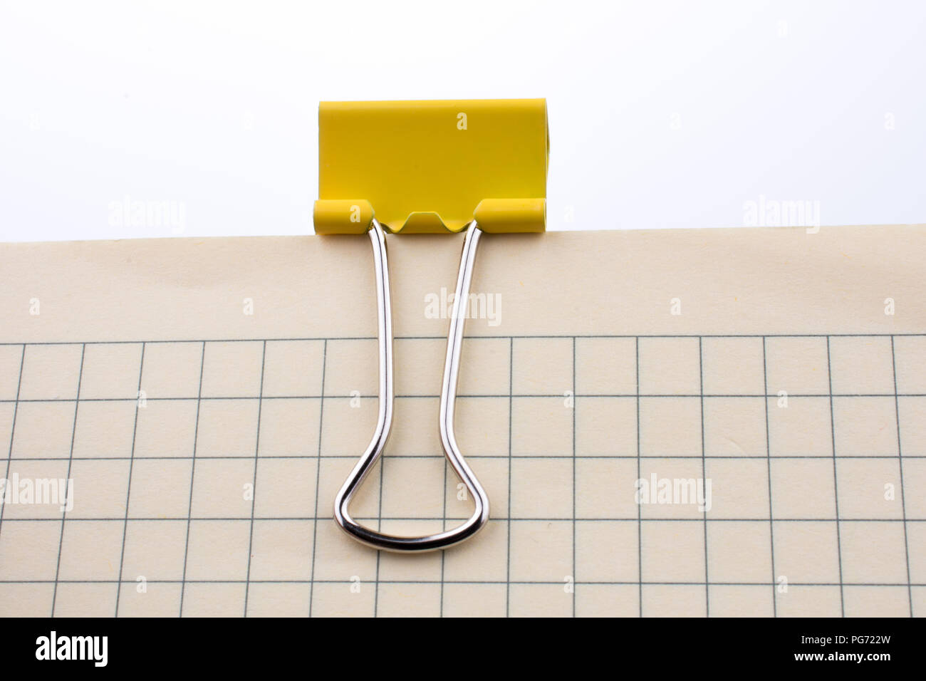 Colored paper clip on a checked notebook  page Stock Photo