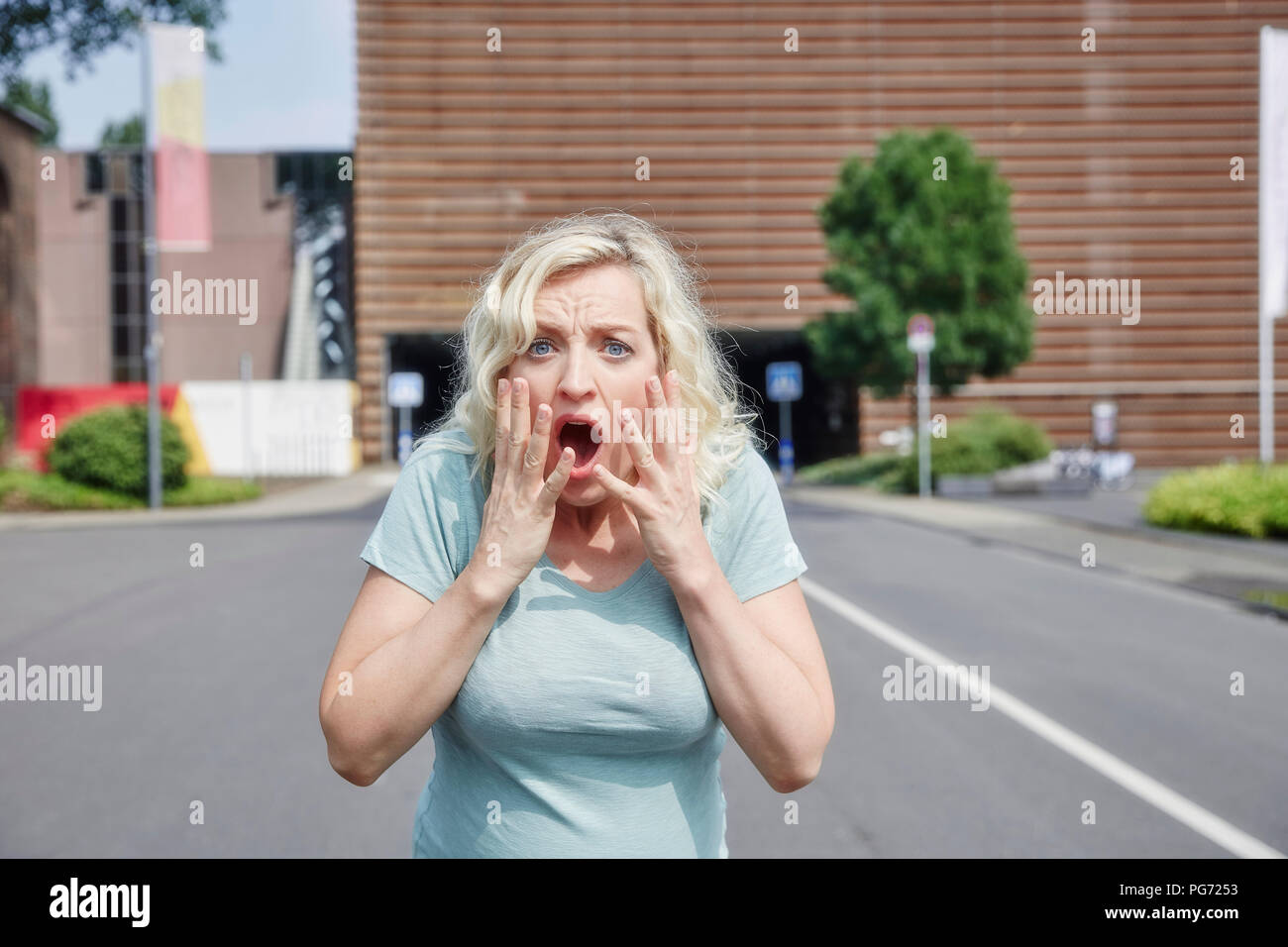 Portrait of shocked woman outdoors Stock Photo