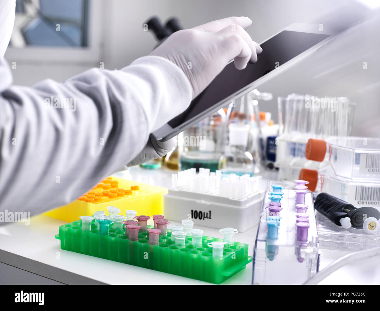 Scientist adding data online via a tablet from a experiment Stock Photo