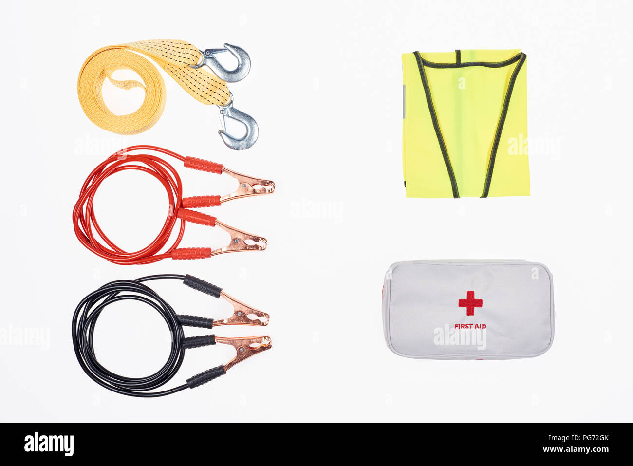 flat lay with car tow rope, jump start cables, first aid kit and