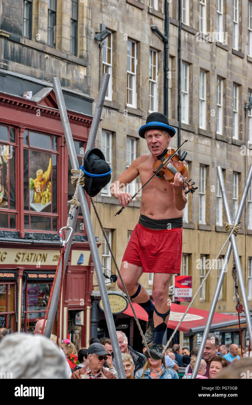 EDINBURGH FESTIVAL FRINGE 2018 TIGHTROPE WALKER PLAYING A VIOLIN WITH ONE FOOT ON THE ROPE Stock Photo