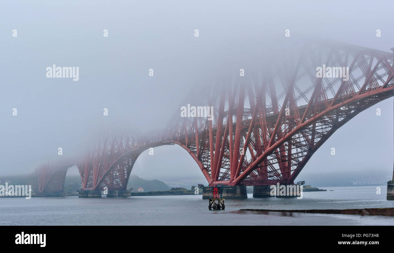 FORTH RAILWAY BRIDGE OVER THE FIRTH OF FORTH SCOTLAND EMERGING FROM EARLY MORNING MIST Stock Photo