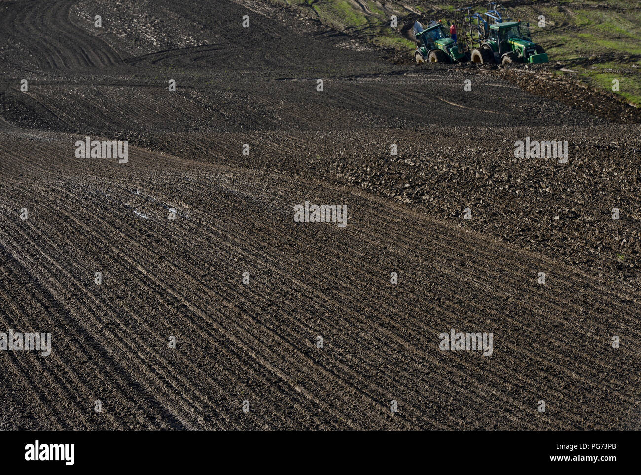 Germany, farming with extreme wet soil conditions after heavy rainfall for days, two big John Deere tractors deadlocked in the furrow Stock Photo