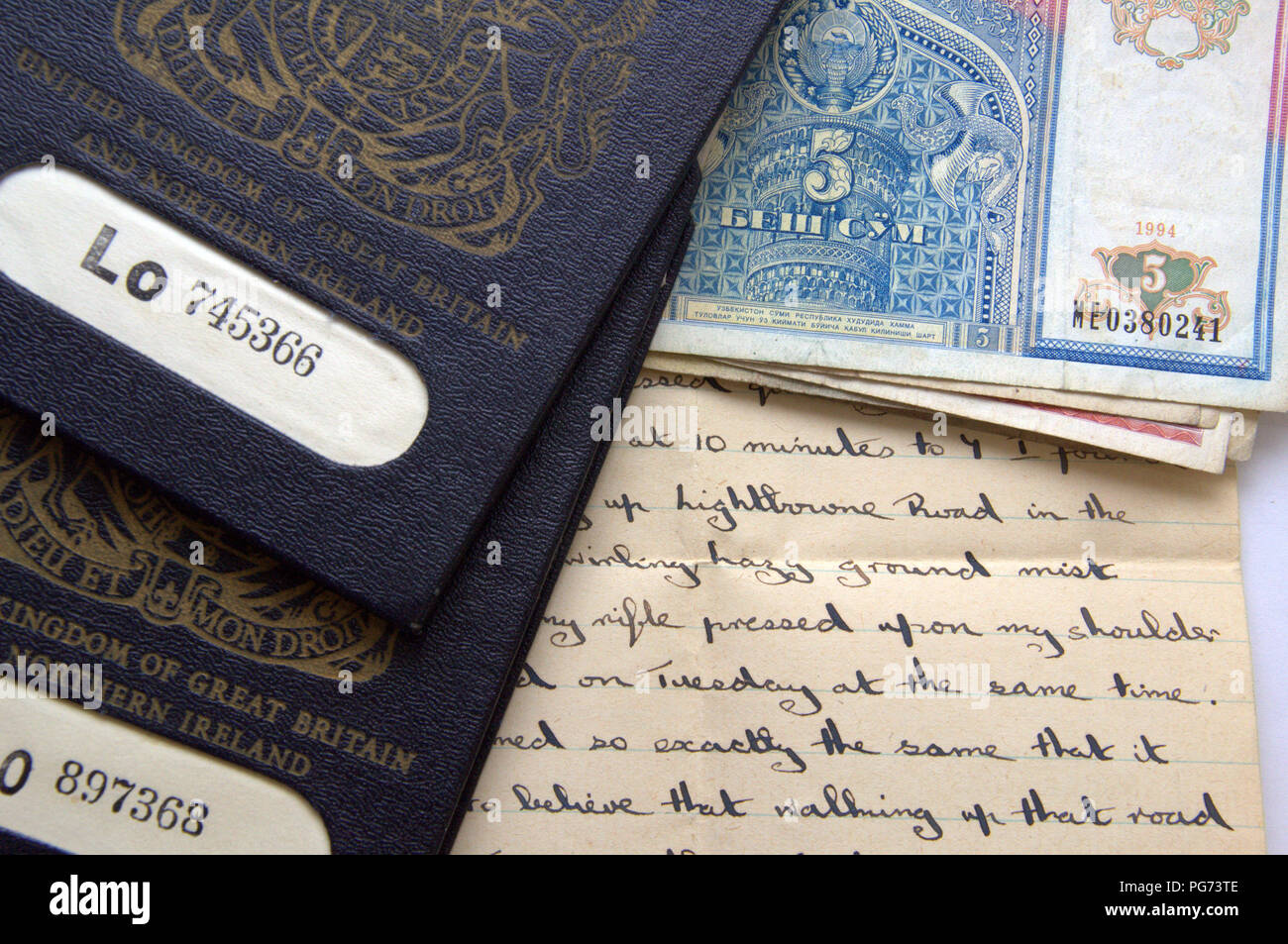 Still life shot of two old style, blue British passports with old handwritten letter and foreign banknotes Stock Photo