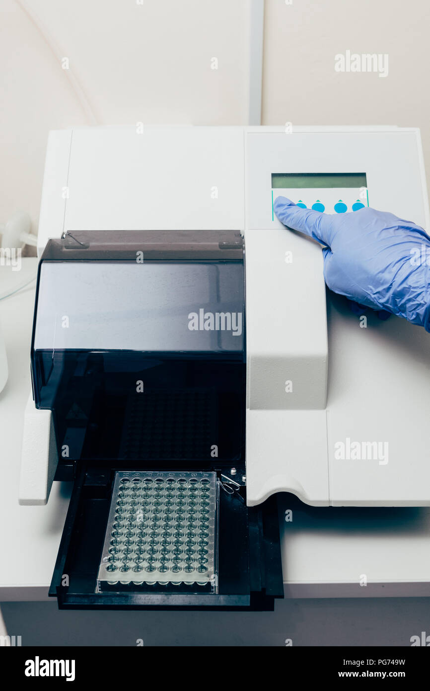 cropped image of scientist using pcr cycler in biotechnology laboratory ...