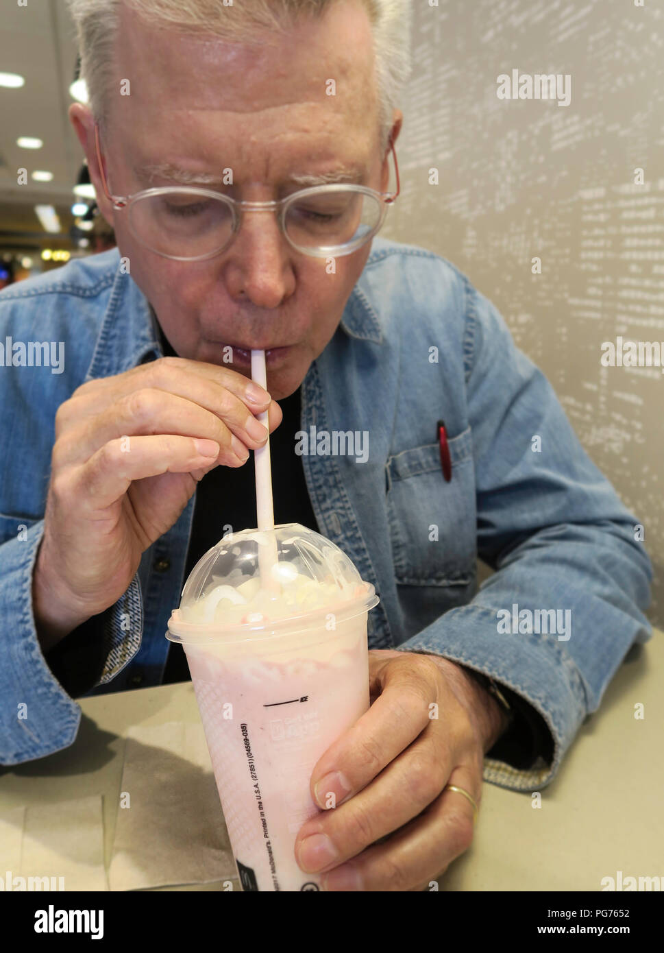 Senior man enjoying a McDonald's Milkshake, USA Stock Photo