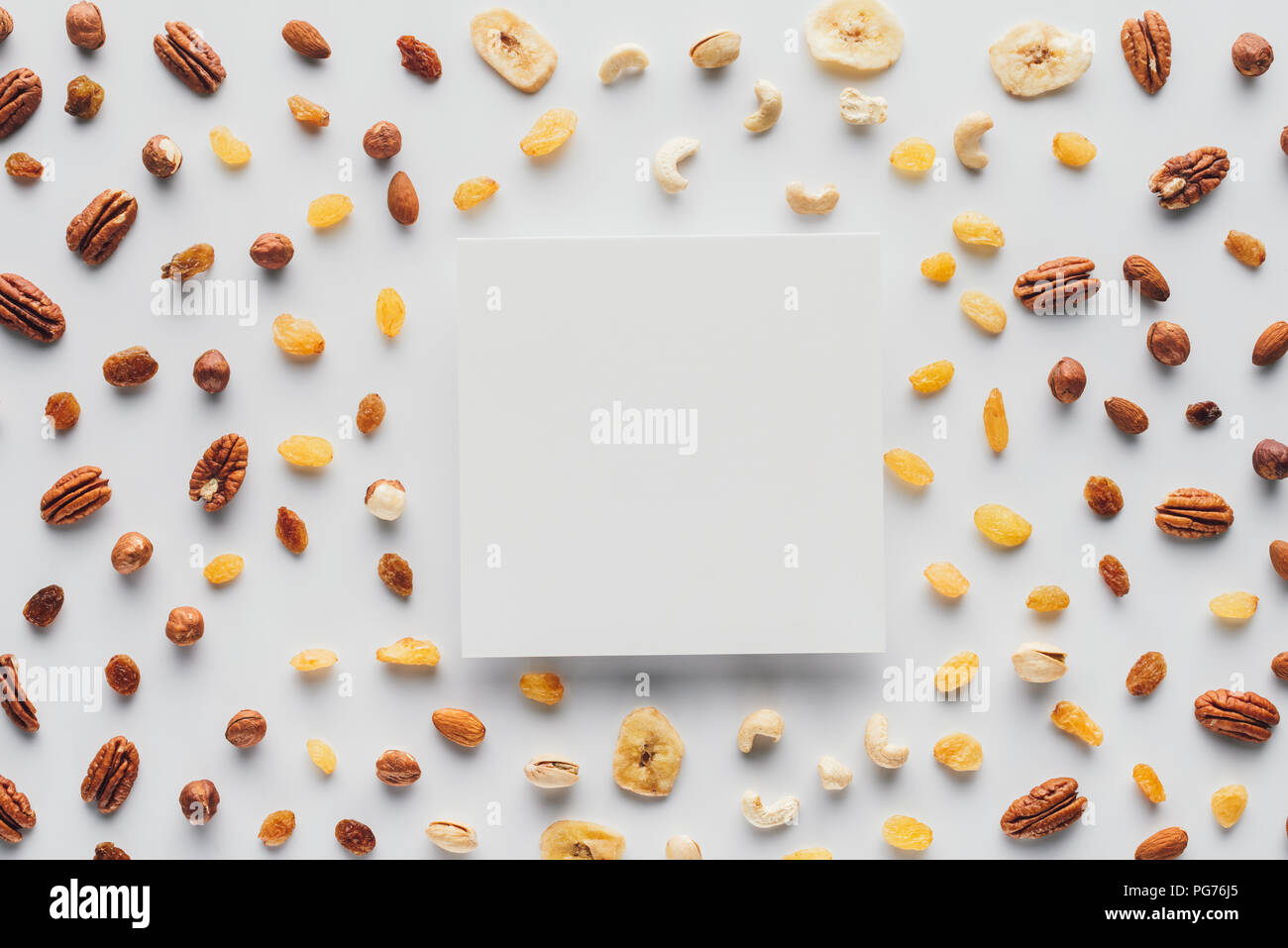 flat lay with various dried fruits and nuts with copy space in center isolated on white background Stock Photo