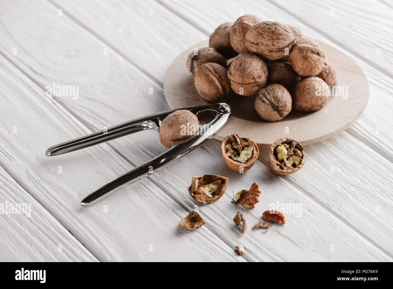 walnuts with metal nutcracker on wooden background Stock Photo