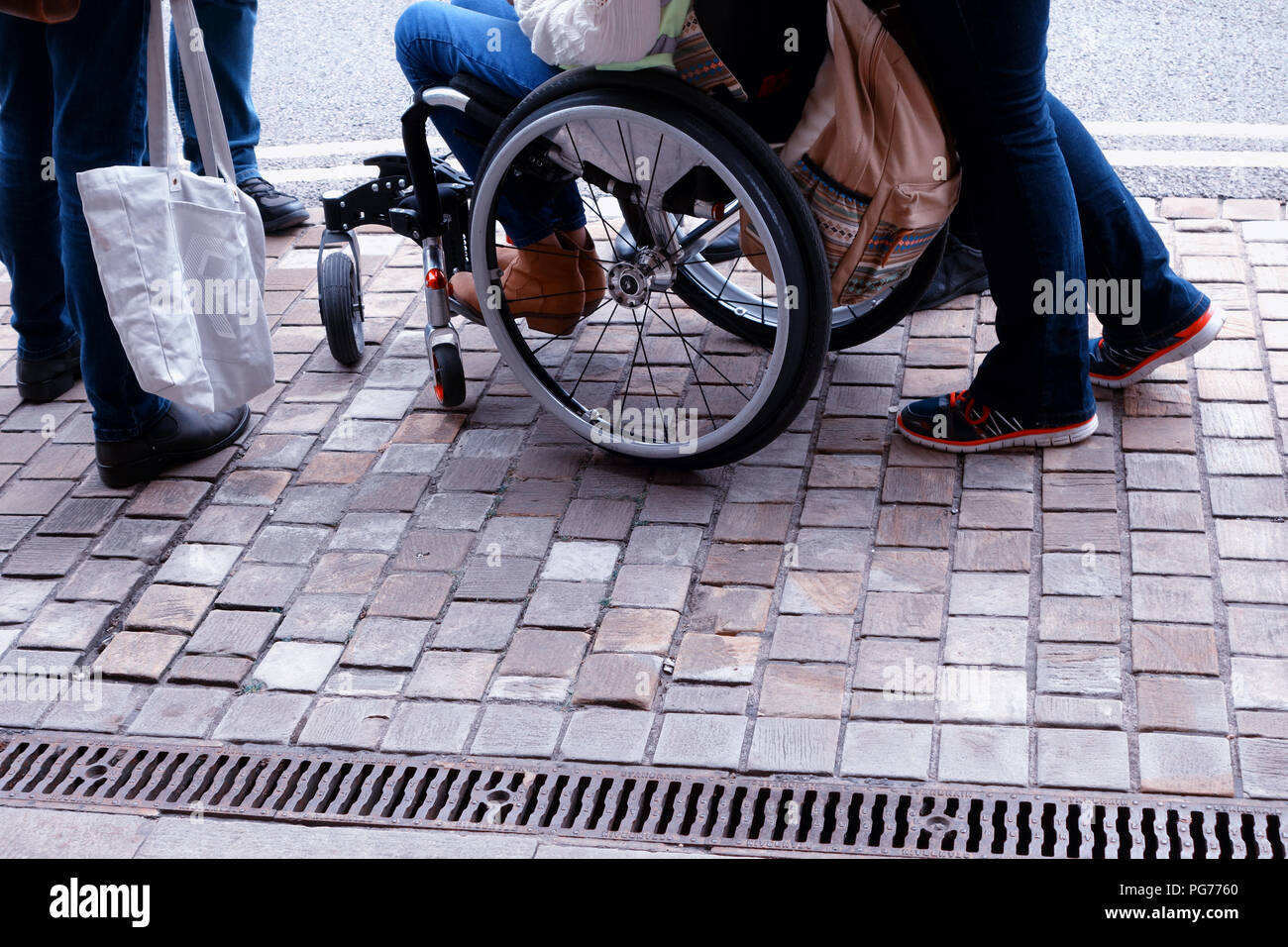 Wheelchairs being pushed along the cobbled areas around the streets of