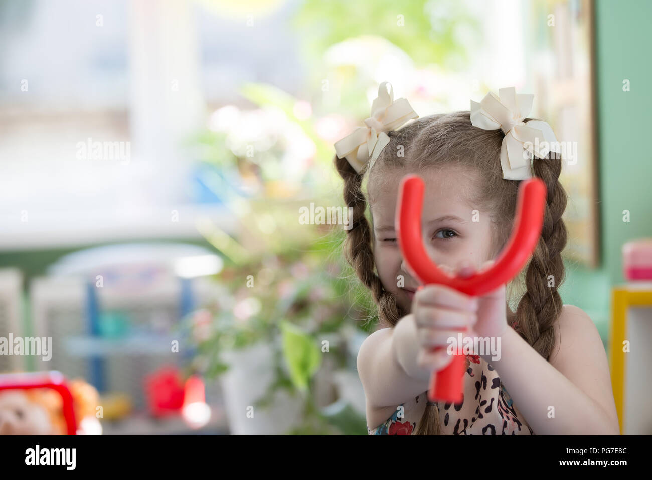 Belarus, Gomel, May 29, 2018. The kindergarten is central. Open Day.Pre-school girl with slingshot Stock Photo