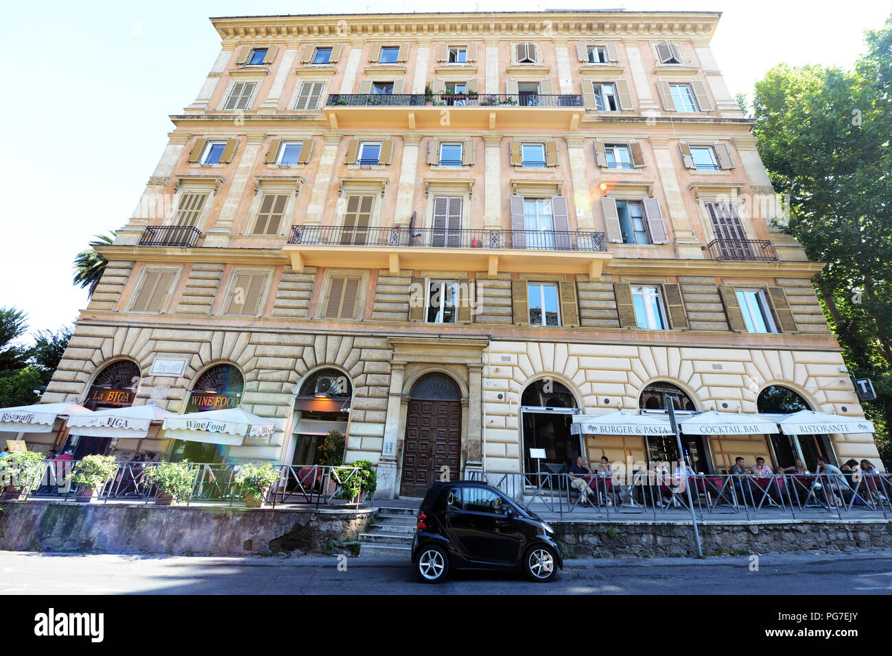 A small Smart car by a beautiful old & big building in Rome, Italy. Stock Photo